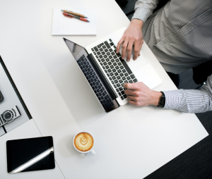photograph of man working on computer from above