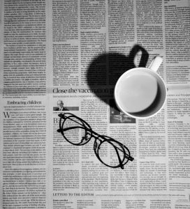 defamation attorney photo of newspaper with glasses and mug