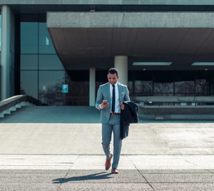 suited man walking from office block colour photo